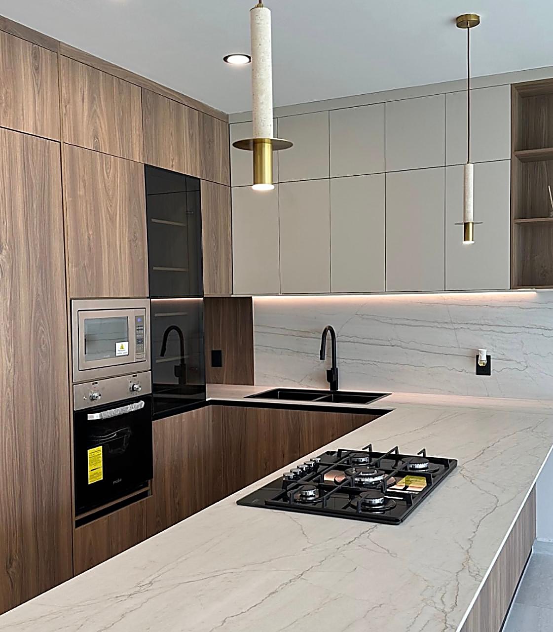 Eden Villa Estate Limuru — Modern kitchen with wood-grain and white cabinetry, marble splashback and built-in appliances at Eden Villa Estate, Limuru, by Epique Interiors.