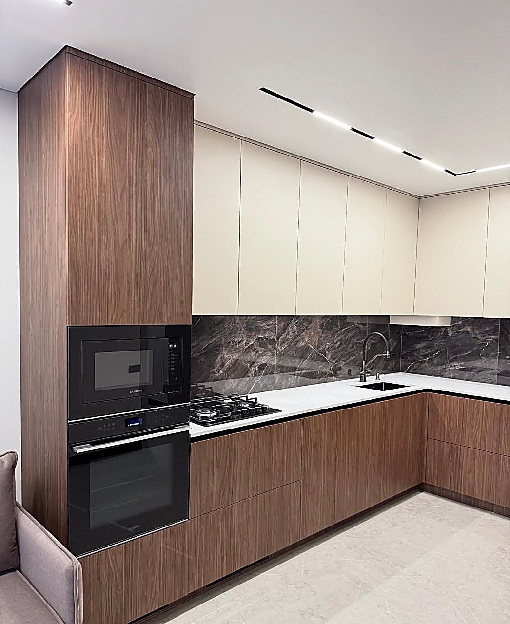 Oak Valley Westlands — Kitchen with walnut and cream cabinetry, dark marble splashback and integrated appliances at Oak Valley, Westlands, Nairobi, by Epique Interiors.